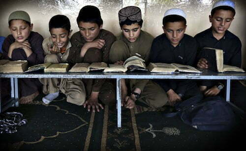 Boys read the Koran in a madrasa, or religious school, during th