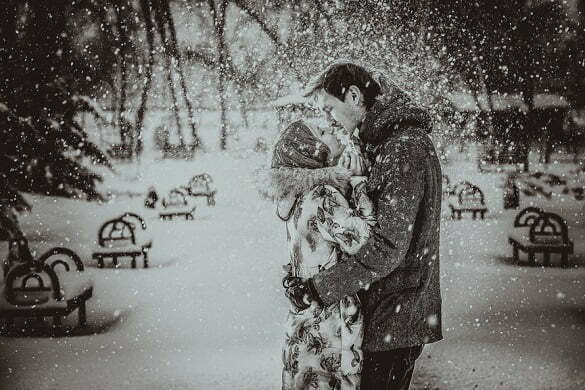Young couple kissing on snow. Black and white.